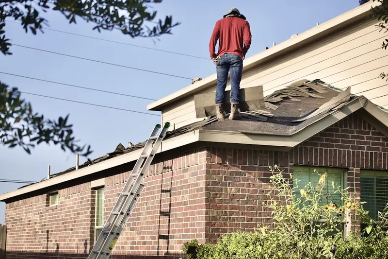 Professional roofer working on a residential roof in Evergreen Village
